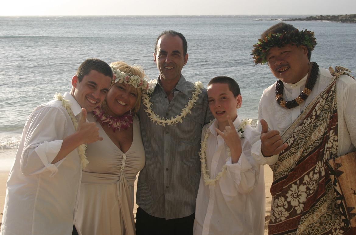 Anne with family on the beach wearing leis